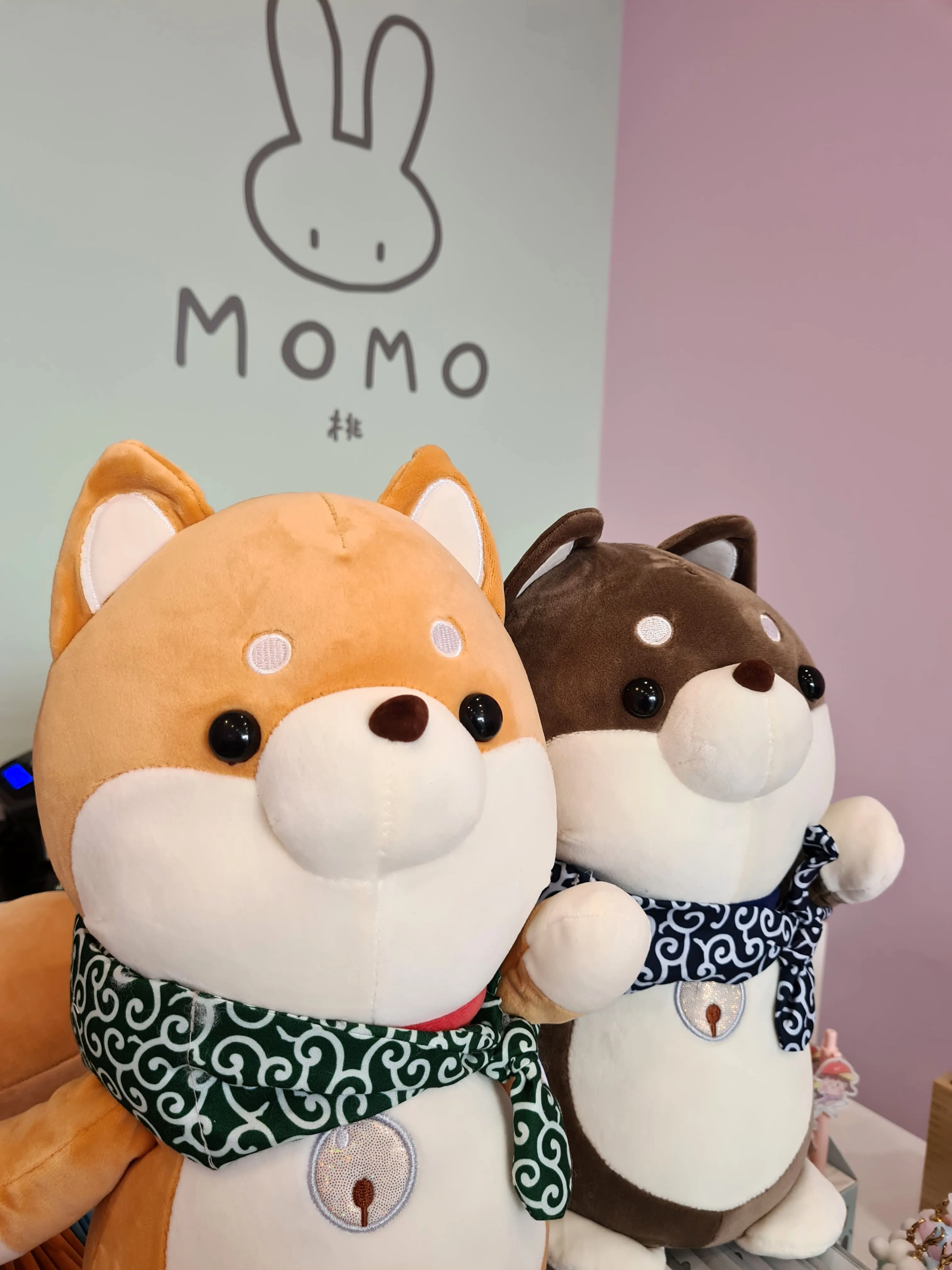 Peluche di cagnolini con dietro il logo di momo
